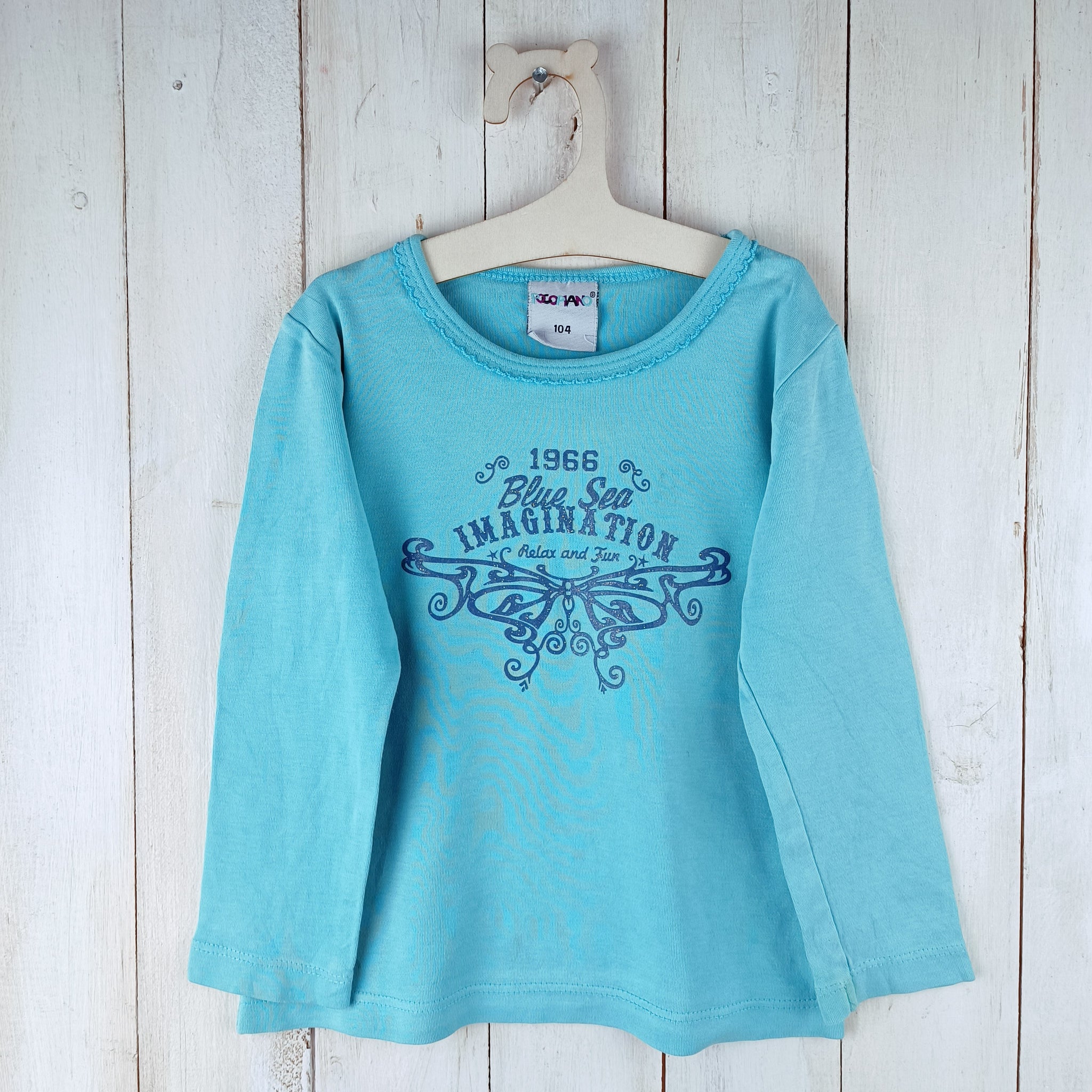 Polera Poco Piano T2 Calipso. Letras azules Brillo