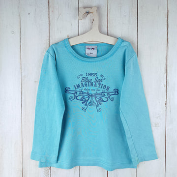 Polera Poco Piano T2 Calipso. Letras azules Brillo