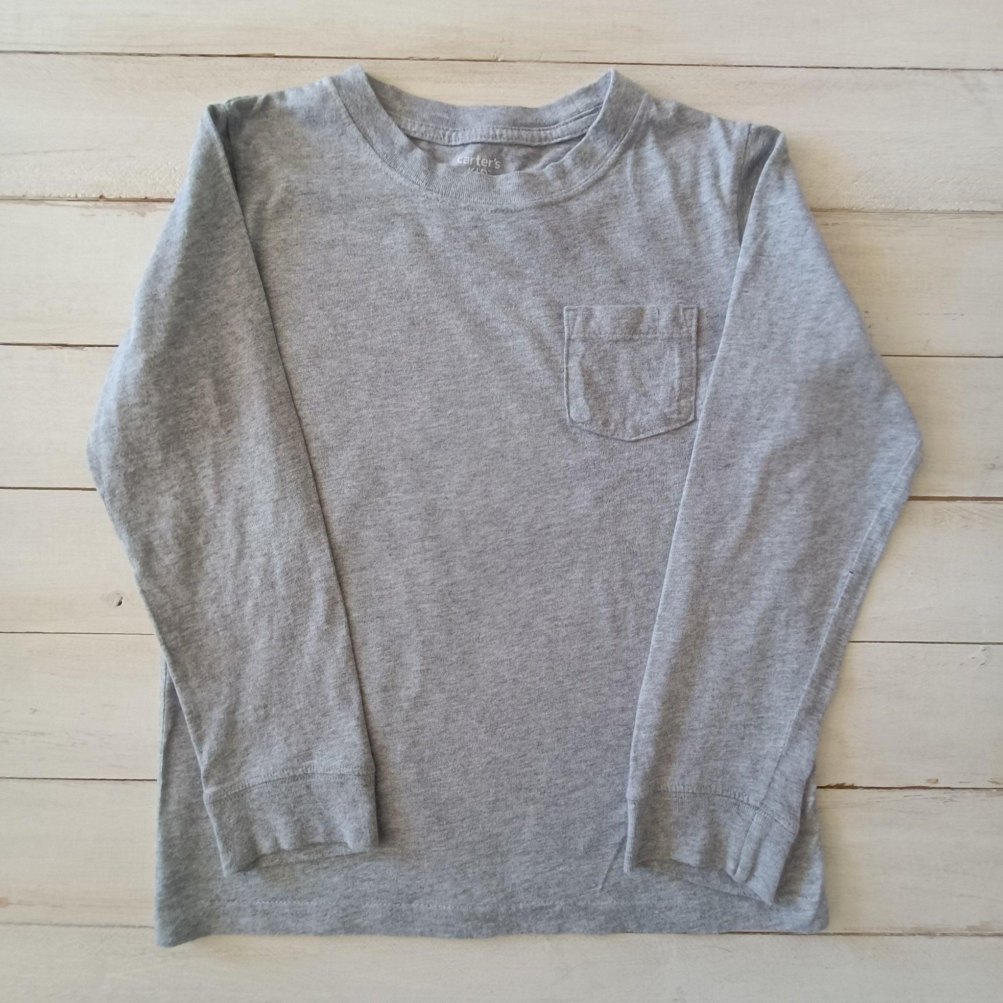 Polera Carter´s  T7 Gris claro con bolsillo.